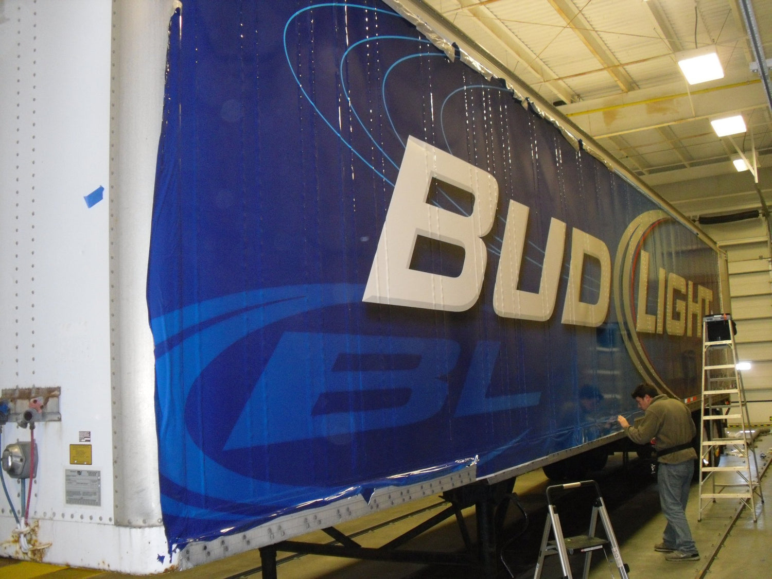 Tractor trailer vinyl wrap installed by All Signs & Graphics Inc. Large blue background and Bud Light make up the design for this corporate fleet graphic vinyl wrap.