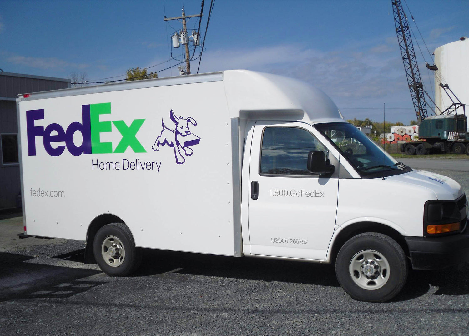 Cast vinyl decals installed on delivery van by All Signs & Graphics Inc. Purple and green FedEx logo with dog and "home delivery" vinyl letting is pictured.